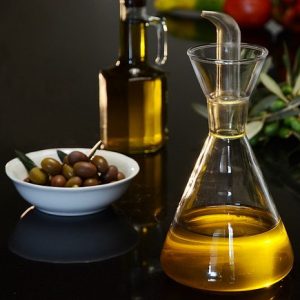 Aceite de oliva virgen. Imagen de aceitera con aceitunas.